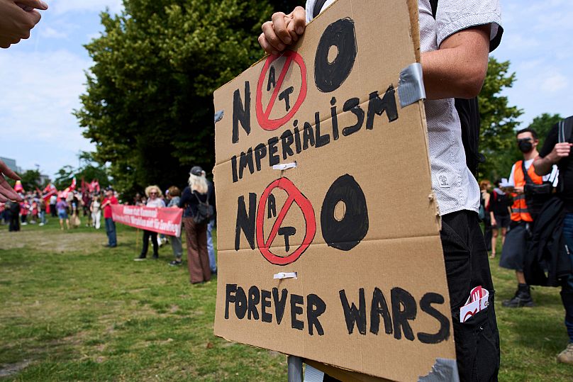 Egy férfi plakátot tart a NATO -csúcstalálkozó előtti tüntetés során, a hágai Hollandiában, 2025. június 22 -én, vasárnap. 