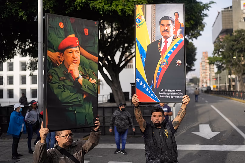 A kormány támogatói 2026. január 3-án, szombaton kihelyezik Nicolás Maduro venezuelai elnök és Hugo Chávez volt elnök plakátjait a venezuelai Caracas belvárosában.