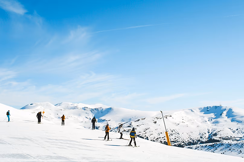 Emberek síelnek egy lejtőn Spanyolországban