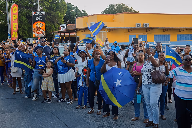 Tömegek buzdítják Curaçao játékosait a 2026-os labdarúgó-világbajnokságra való kvalifikációt ünneplő felvonuláson Willemstadban, 2025. november 19.