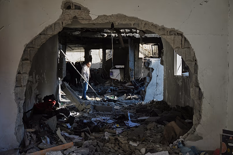 Egy palesztin megvizsgálja az al-Hawli család házának romjait, amely egy izraeli csapás során elpusztult Deir al-Balahban, a Gázai övezet középső részén, 2026. január 16-án, pénteken