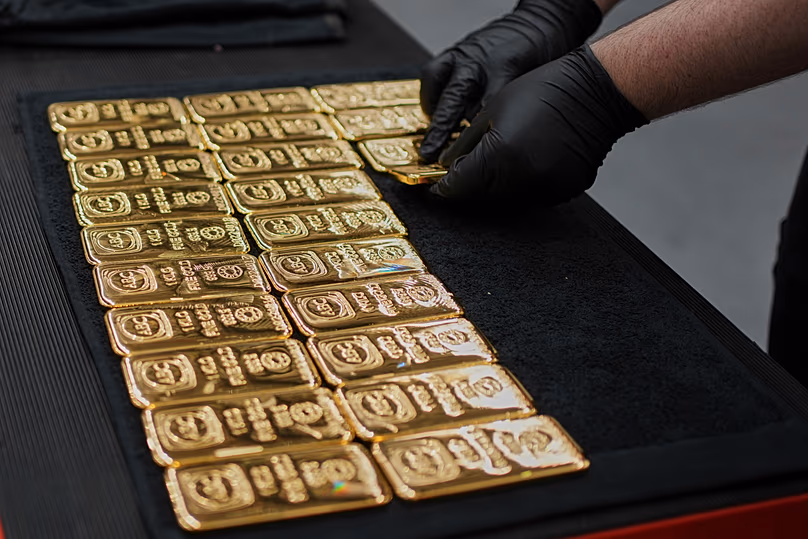 Egy munkás egy kilogrammos aranyöntvény rudakat rak ki a sydneyi ABC Finomítóban, 2025. április 30.