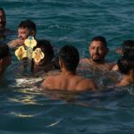 Fiatal férfiak Görögországban vízkereszt ünnepén fából készült keresztért merülnek