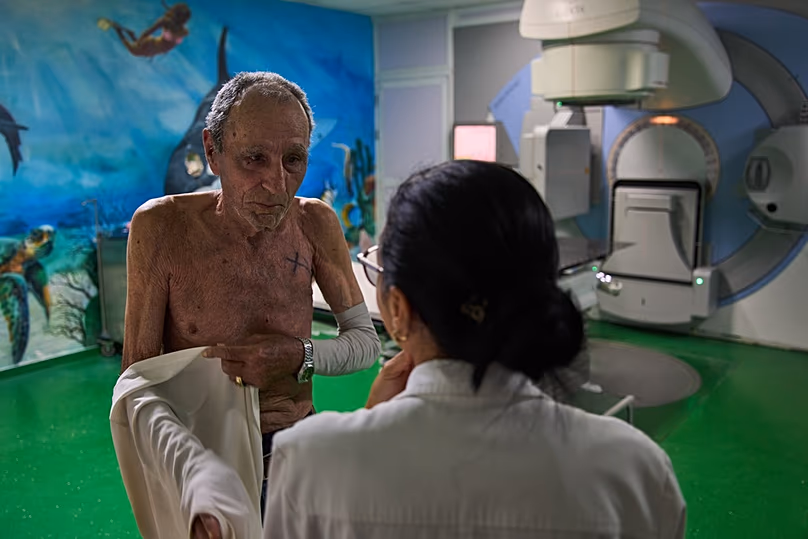 Jorge Elias beszél az orvossal a Havanna Nemzeti Onkológiai és Radiológiai Intézetben, 2026. február 20-án, pénteken végzett sugárterápiás ülése után.