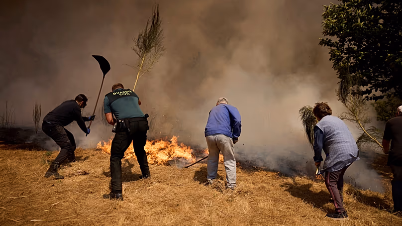 A lakosok futótűzzel küzdenek az északnyugat-spanyolországi Ourense közelében lévő Rebordondo falu felé, 2025. augusztus 18-án.