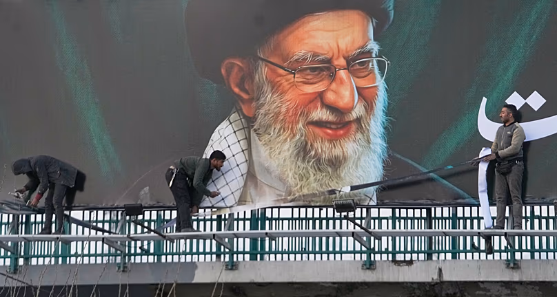 A munkások Ali Khamenei ajatollah néhai iráni legfelsőbb vezető óriásplakátját helyezték el Teheránban, 2026. március 2.