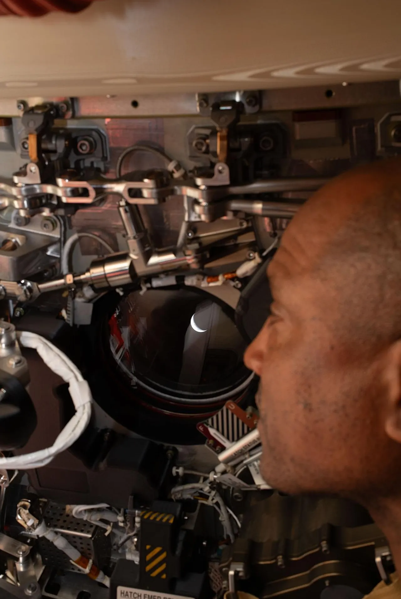 Az Artemis II pilóta és Victor Glover NASA űrhajós az Orion űrszonda egyik ablakán néz vissza a Földre. 