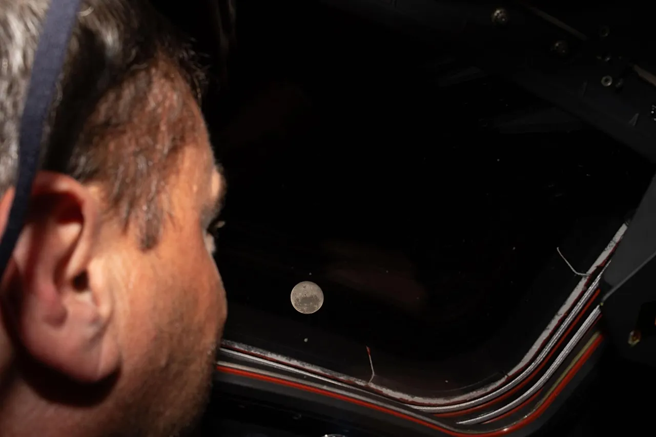 Az Artemis II parancsnoka és Reid Wiseman, a NASA űrhajósa az Orion űrszonda egyik fő kabinablakán néz ki a Holdra