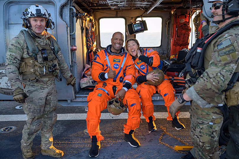 A NASA által készített fotón az űrhajósai, Victor Glover, az Artemis II pilótája balra, és Christina Koch, az Artemis II küldetés specialistája a haditengerészet MH-60 Seahawkon ül.