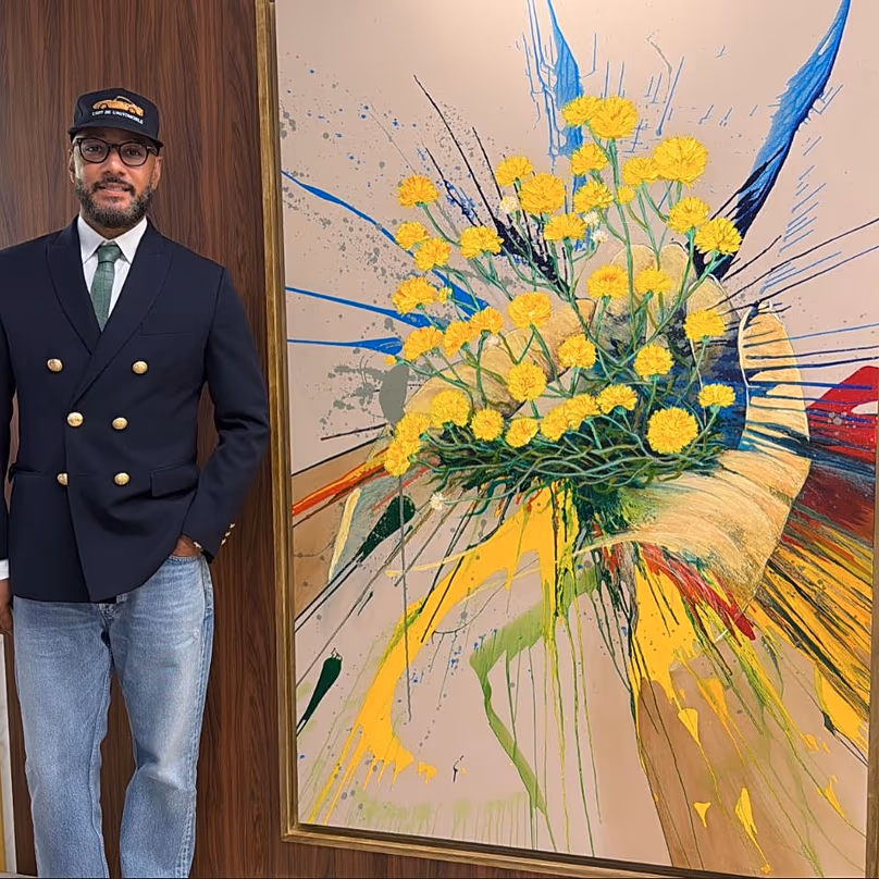 A Swizz Beatz Fatma Al-Naimi katari művész munkája mellett áll.