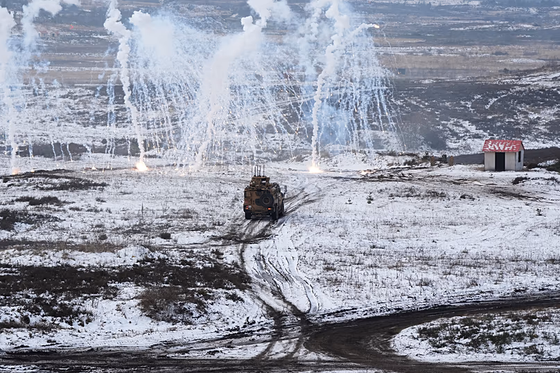 A katonák járművet vezetnek, miközben egy álfaluban ellenséget keresnek és biztosítanak a NATO által vezetett hadgyakorlaton a Bergen melletti katonai bázison, 2026. február 19.