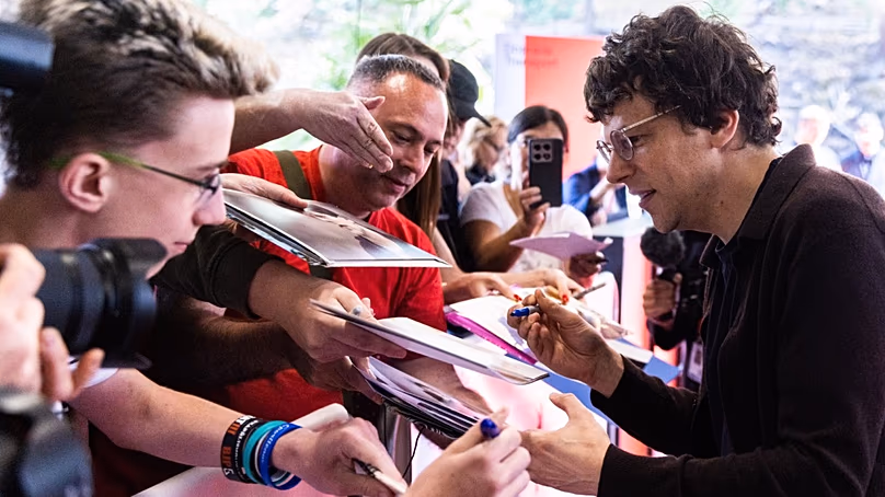 Jesse Eisenberg színész és rendező megáll, hogy dedikáljon a rajongóinak, mielőtt átveszi az elnöki díjat a Karlovy Vary-i filmfesztiválon, 2026. július 2-án.